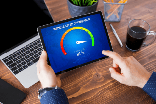 An image of a mans hand interacting with a tablet that has a website hosting performance meter on the screen.